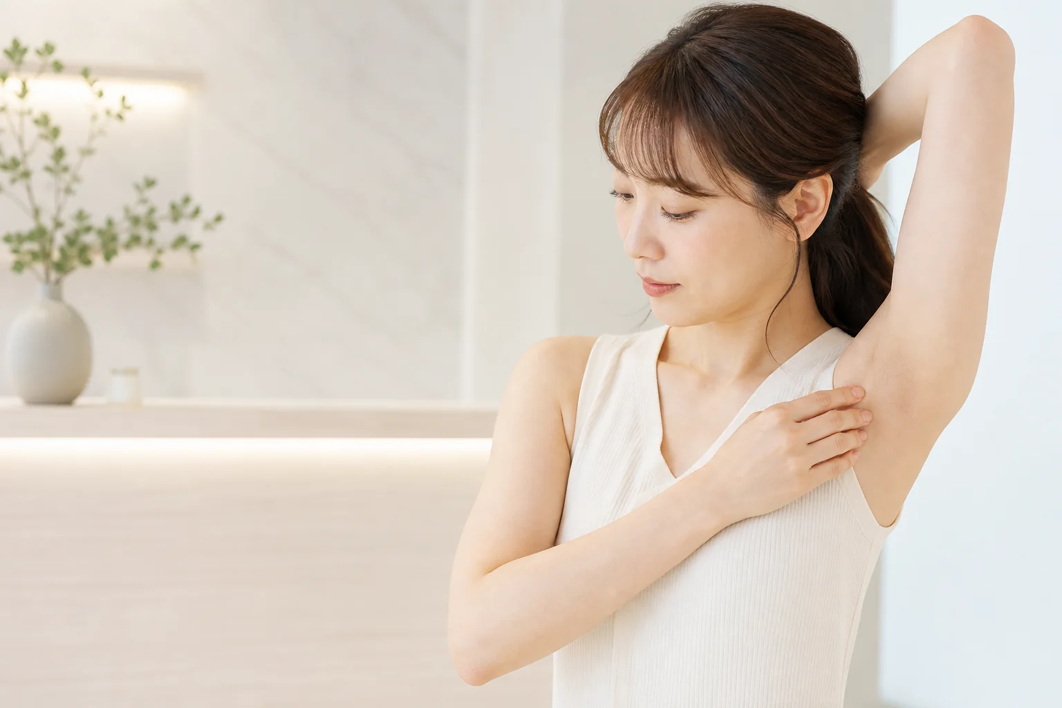 ワキの黒ずみや色むらを確認する女性
